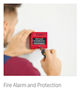 Fire Alarm and Protection – person activating a red wall-mounted fire alarm pull station