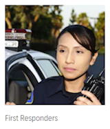 First Responders – police officer holding a portable radio beside a patrol car